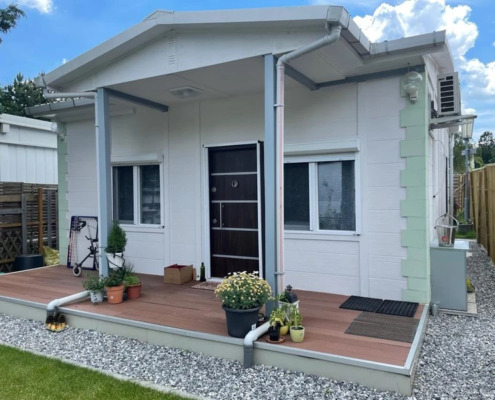 kleines Haus mit paar Blumen vor der Tür